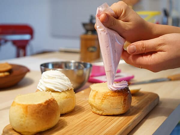 スコーンにクリームを絞っている