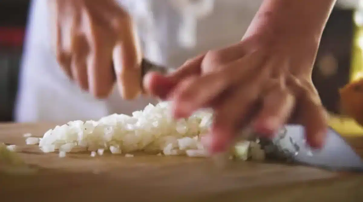 玉ねぎの可能性を感じるオニオンスコーン 包丁で玉ねぎを切っている