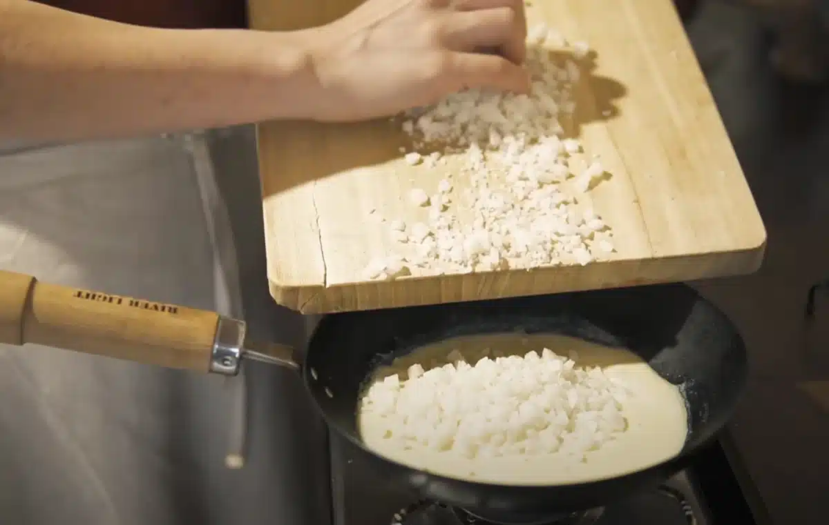 お餅で作るヴィーガンチーズピザのレシピ 温めた豆乳に細かく切ったお餅をいれる