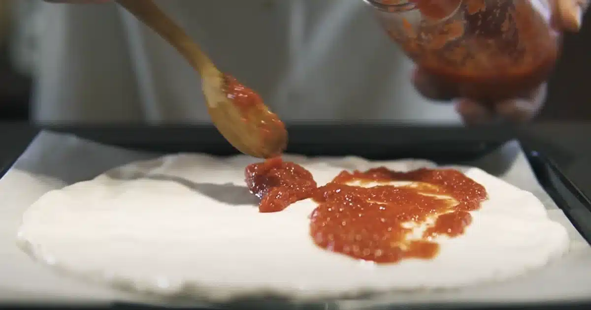 お餅で作るヴィーガンチーズピザのレシピ 生地にトマソースをのせる