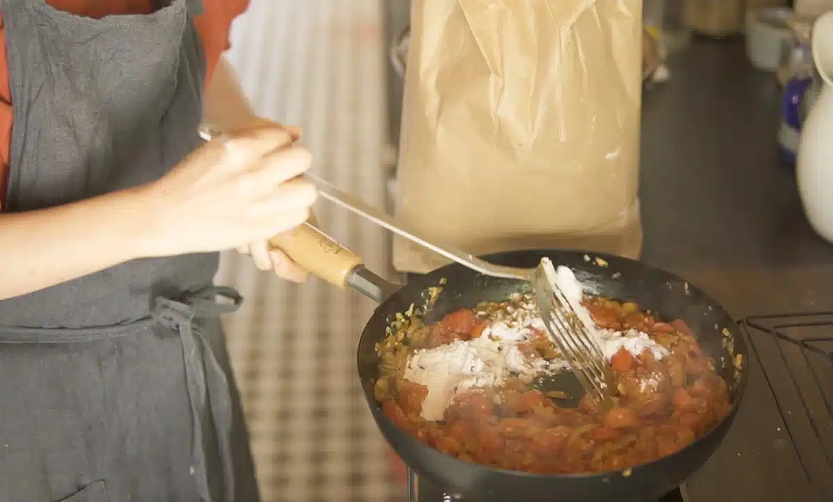 お腹をあっためるルーカレーほっこり風味 フライパンで玉ねぎ、プチトマト、にんじんなどを炒めている